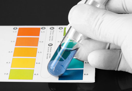 Person Wearing Gloves Testing The PH Of A Chemical In A Test Tub