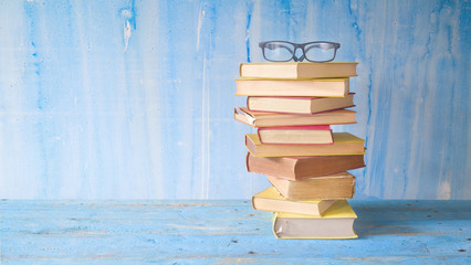stack of old books with spectacles, grungy background