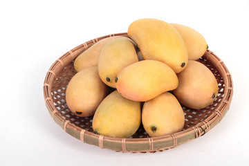Golden ripe mangoes in basket on white background