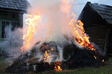 Hay grass burning in peaceful village evening