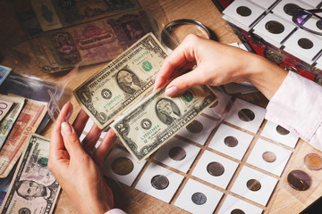Woman looks at the page with bills in the pockets