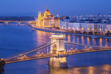 Naklejka premium Budapest city night scene. View at Budapest Chain bridge( Széchenyi Lánchíd original name) , river Danube and famous building of Parliament. Budapest city is capital of east european country Hungary.
