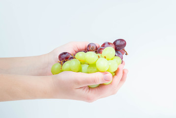 Grapes in a woman's hand on a white background