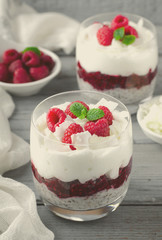 Healthy breakfast, desert, with chia seed pudding, cream, raspberry jam, coconut flakes and fresh berries