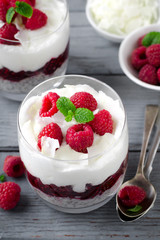 Healthy breakfast, desert, with chia seed pudding, cream, raspberry jam, coconut flakes and fresh berries