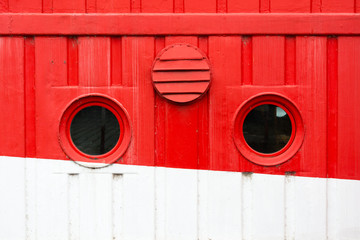 Circular windows on the red and white cruise ship