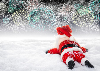 Erschöpfter Weihnachtsmann im Schnee liegend vor Feuerwerkshimmel