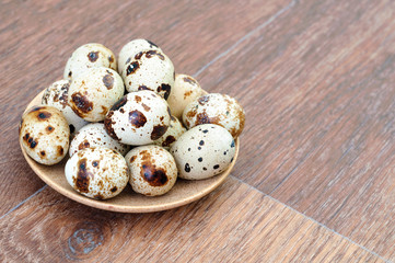 Many Quail eggs in a plate on old wooden table