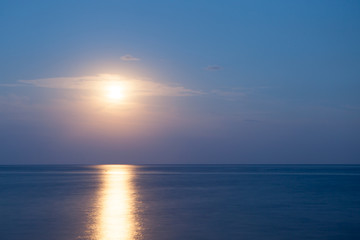 Fototapeta premium Beautiful sunset over sea with reflection in water