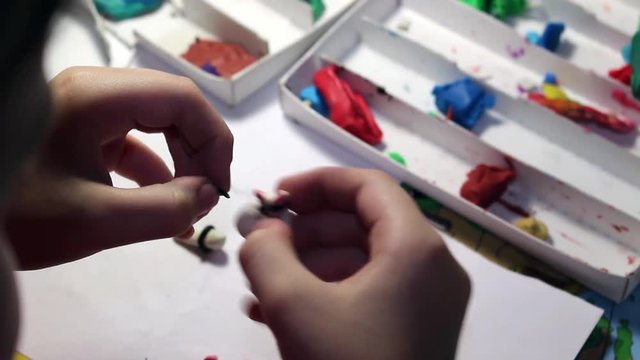 Девочка делает игрушку из пластилина