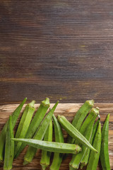 Lady Fingers or Okra over wooden table background. Space for tex