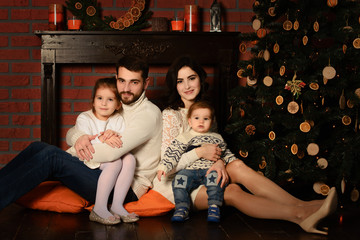 Young family near a christmas tree together.