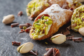 Sweet homemade cannoli stuffed with ricotta cheese cream and pis
