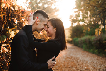 Young couple of pretty girl and man walk outdoors in park