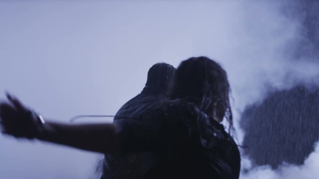 Couple running in heavy rain accross the smoke. Shot on RED EPIC Cinema Camera in slow motion.