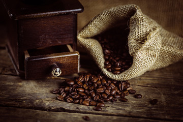 Alte Kaffeemühle und Kaffeebohnen auf einem Tisch