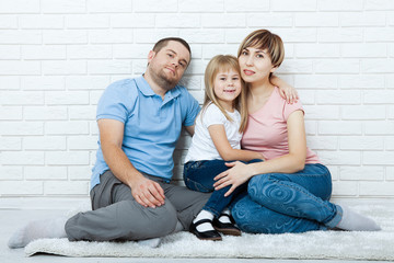 happy family mother, father and two children playing and cuddling at home on floor