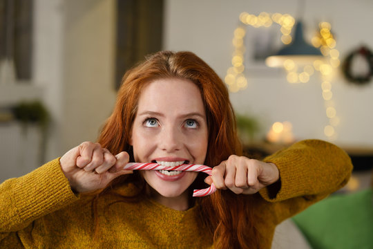frau bei&szlig;t voller vorfreude in eine zuckerstange
