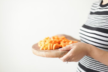 Female hands holding a plate with tomato and carrot slices
