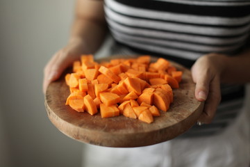 Female hands holding a plate with tomato and carrot slices