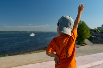 Little boy waves goodbye to the boat, Samara, Russia