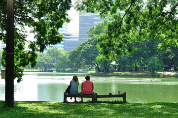 Couple love sitting together on rock bench next to big lake