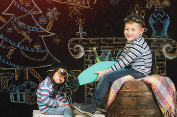 Fototapeta na wymiar Cheerful siblings playing with a toy plane. Dreams about new year trip
