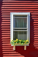 Fototapeta na wymiar White small window on a red wood wall.