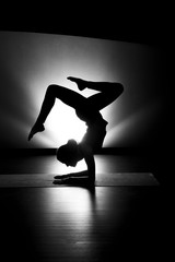 Woman doing yoga forearm stand pose silhouette black and white