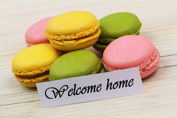 Welcome home card with stack of colorful macaroon biscuits
