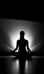 Woman doing yoga meditation silhouette black and white