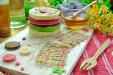Stack of color pancake with honey and flower.