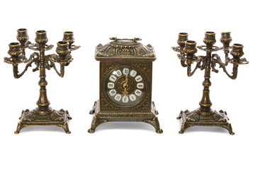 Two vintage bronze candle holder and clock on a white background
