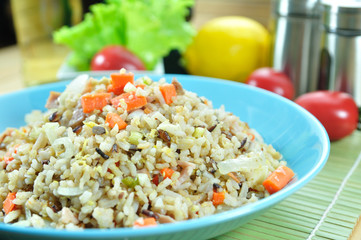 Chicken ham fried rice with carrot in blue plate set up on table
