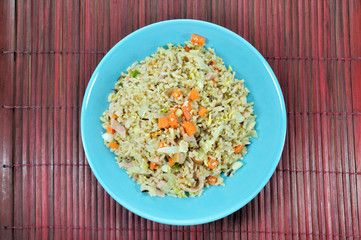Chicken ham fried rice with carrot in blue plate set up on table