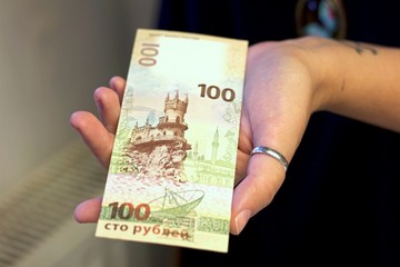 Hundred ruble banknote in female hands, Russian money