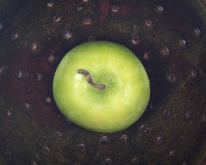 Green organic granny smith apple in ceramic berry bowl