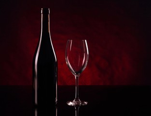 Bottle of red vine and empty vineglass
