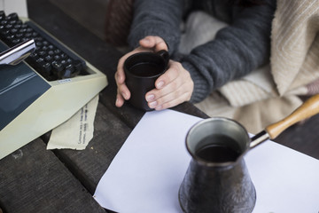 Fototapeta na wymiargirl drinking coffee and typing on a typewriter