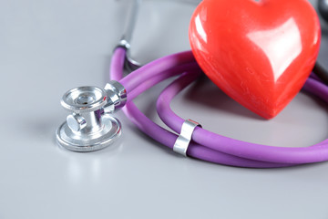 Red heart and a stethoscope on desc