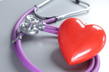 Red heart and a stethoscope on desc