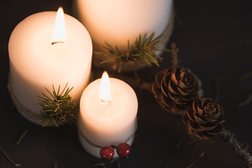 Christmas decorations on tha table with lit candles