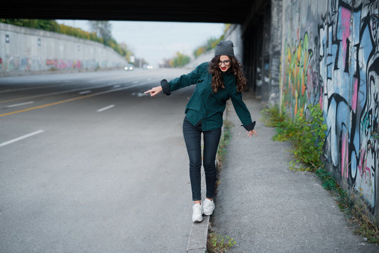 Young girl walk on the sidewalk looking at feet