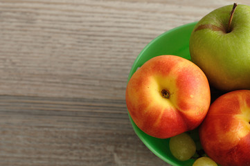 A variety of fruit in a green plastic bucket