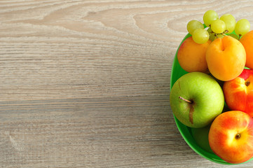 A variety of fruit in a green plastic bucket