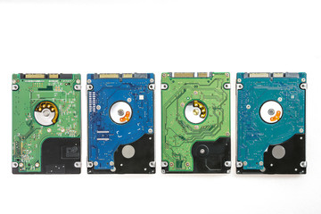 Four different 2.5 inch laptop HDD's. View of the back side, from the PCB. Isolated on white background.