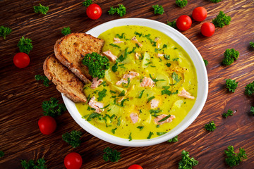Creamy fish Salmon, leek, potato soup on wooden background