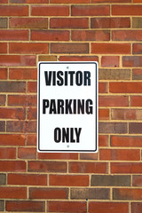 Visitor parking sign on a business wall