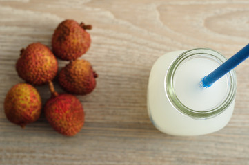 Litchi juice in a glass bottle with a blue straw 