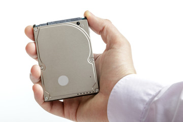 Man's hand holds a 2.5 inch hard drive. View of the upper part of the HDD. Isolated on white background.